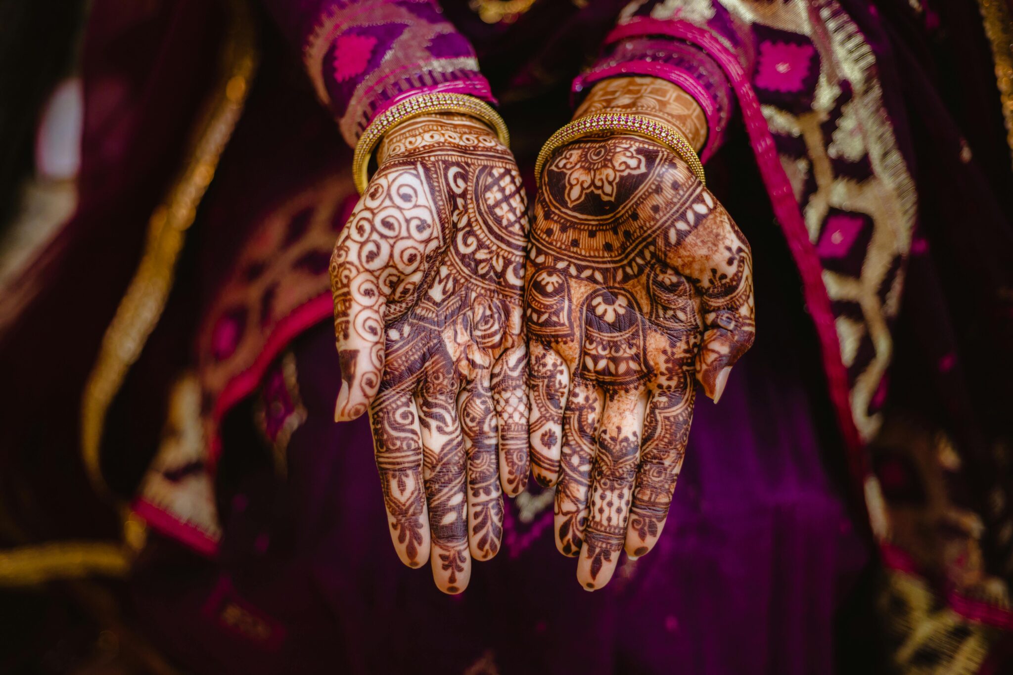 Close-up of henna art on bride's hands, showcasing Indian cultural richness and tradition.